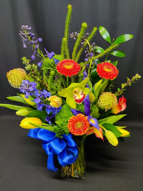 uncommon valentine's mix of bold blue yellow and orange flowers